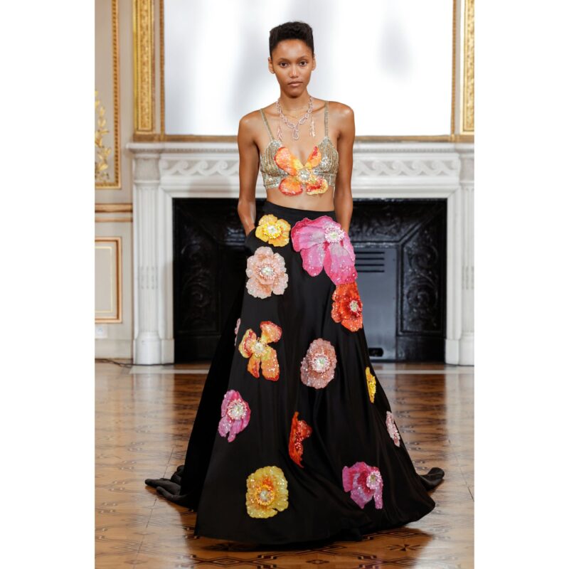 Floral Glitz: A model wearing a black and golden co-ord with colourful flowers designed on it