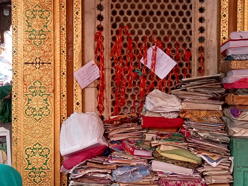 KNOTTED HOPE: Red-colored thread and arziyan at Nizamuddin Dargah
