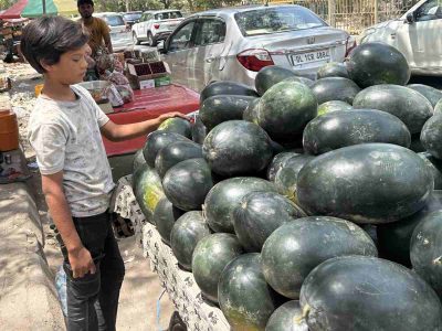 A boy selling watermelon on a cart