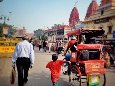 Racing for a Living: A barefoot boy runs toward a crowded area, hoping to earn money from tourists. His swift steps reflect a life driven by necessity and hope