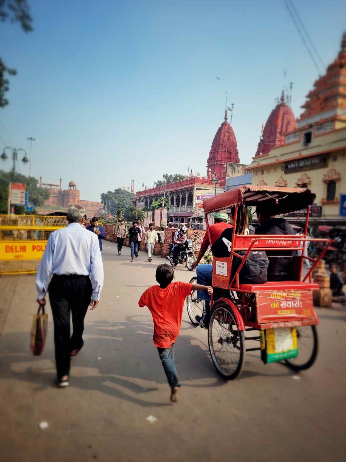 Children: Racing for a Living: A barefoot boy runs toward a crowded area, hoping to earn money from tourists. His swift steps reflect a life driven by necessity and hope