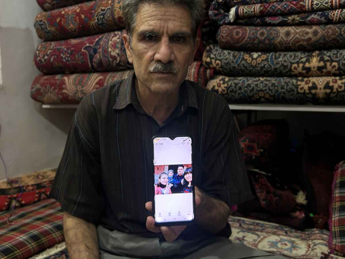 Abdul Hadi Faraz shows a photograph of his family during their first visit to India for his daughter’s cancer treatment